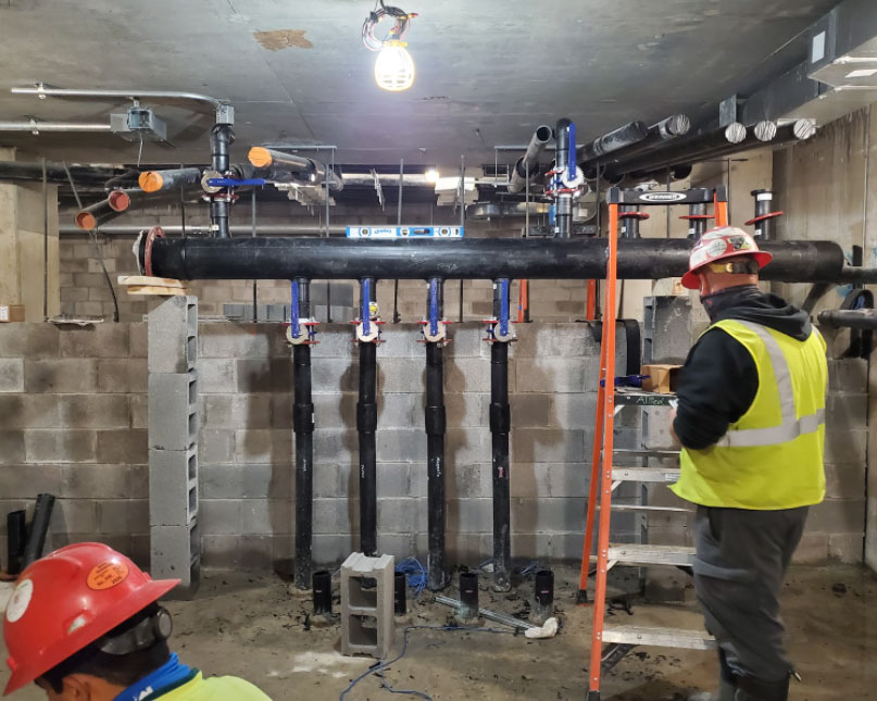 Interior geothermal mechanical piping installation at Marcus Garvey Apartments Phase 1.