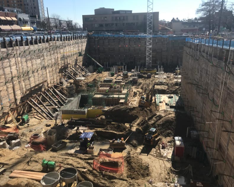 Deep commercial excavation site at Wheaton Town Center prepared for geothermal construction and foundation work.
